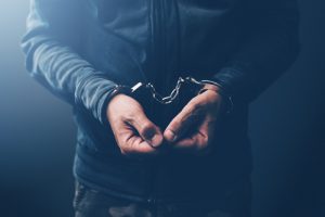 man in handcuffs facing hate crime charges in Boulder