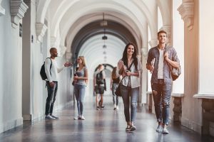 students walking in a hallway at a university | Crime on Colorado Campuses